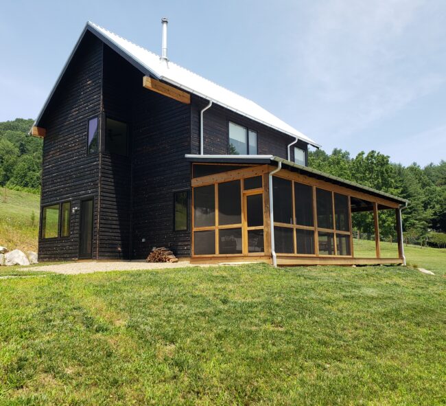 Minimalist Scandinavian farmhouse with wrap around screen porch