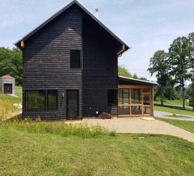 Modern Scandinavian Farmhouse with burnt wood exterior and screened in porch